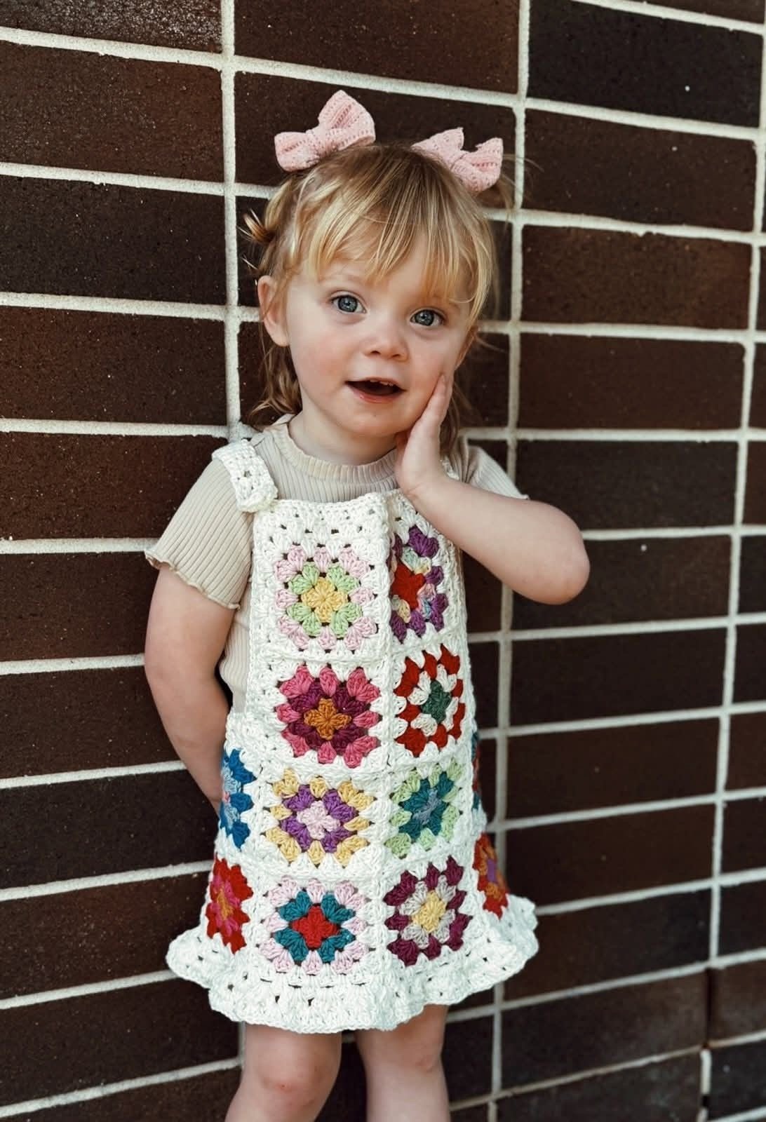 Criança com vestido de crochê de flores coloridas