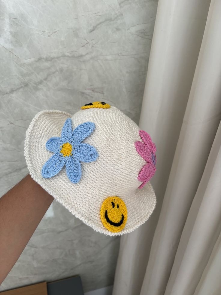 Chapéu branco com flores coloridas e carinhas sorridentes